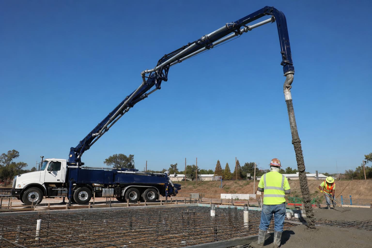 Concrete discharged from a boom pump onto an elevated structural deck during a commercial pour.
